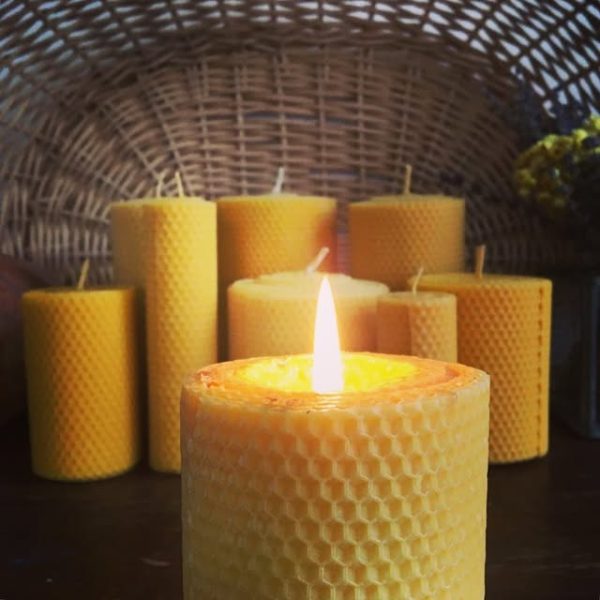 Hand-rolled honeycomb beeswax candles glowing in warm light